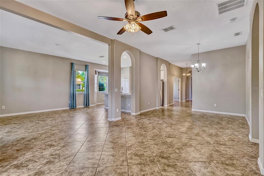 A kitchen features white cabinets, stainless steel appliances, a breakfast bar, and tile flooring — 115 CRESCENT MOON DRIVE, GROVELAND, FL