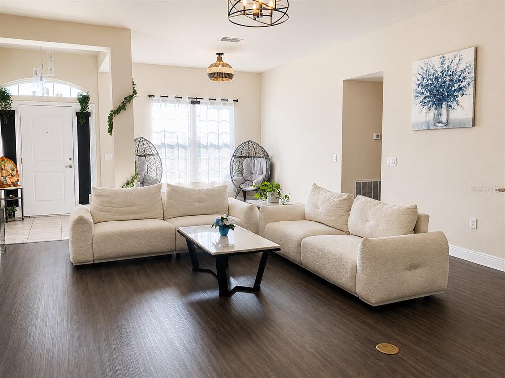 A living room features a cream-colored sectional sofa, a marble coffee table, and two egg chairs — 4590 BROOKSHIRE PLACE, LAKE WALES, FL