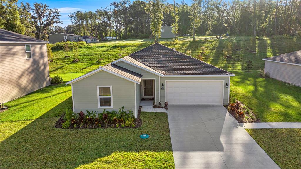 An aerial view of a light green single-story house with a two-car garage and lawn — 16927 NW 144TH STREET, ALACHUA, FL