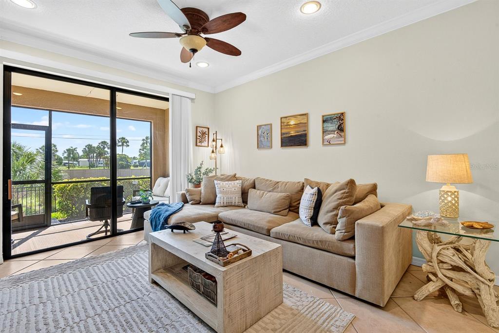 A kitchen with wood cabinets, stainless steel appliances, and a pass-through window to the dining area — 7228 HAMILTON ROAD UNIT 7228, BRADENTON, FL
