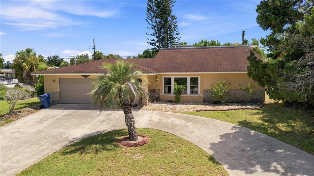 A single-story house with a brown roof, tan exterior, and a curved concrete driveway — 352 LAKE ROAD, VENICE, FL