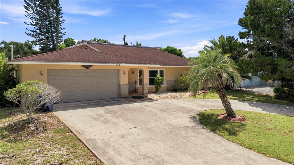 A single-story house with a tan exterior, a brown roof, and a concrete driveway — 352 LAKE ROAD, VENICE, FL