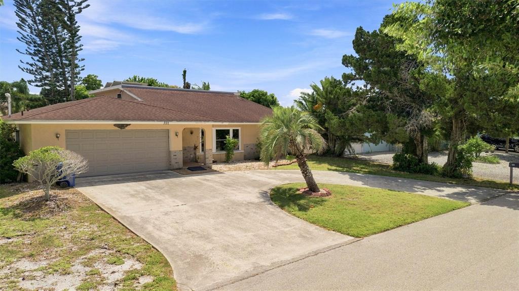 A single-story house with a brown roof, beige exterior, and a concrete driveway — 352 LAKE ROAD, VENICE, FL