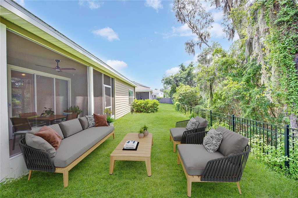 A backyard patio features modern outdoor furniture set on a lawn beside a screened porch — 13639 NW 13TH PLACE, NEWBERRY, FL