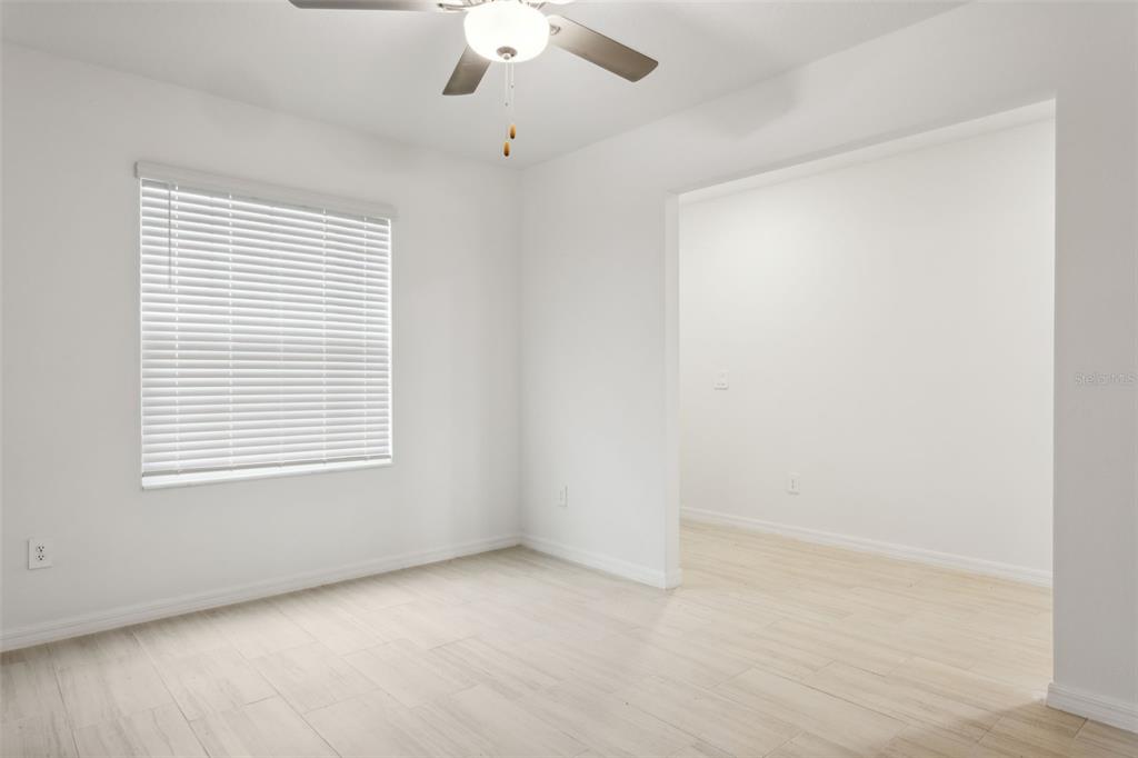 A bright room with white walls, light wood-look tile flooring, and a ceiling fan — 32309 WISHING HAVEN DRIVE, SAN ANTONIO, FL