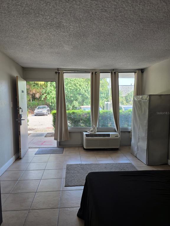 A bedroom with tile flooring, a window air conditioner, and a door leading outside — 7900 S ORANGE BLOSSOM TRAIL UNIT 1055, ORLANDO, FL