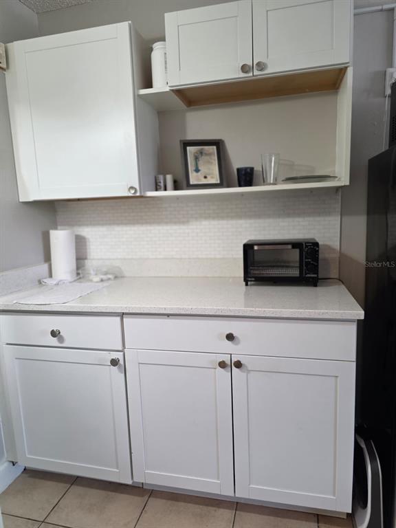 A kitchen area features white shaker cabinets, a light countertop, and a small toaster oven — 7900 S ORANGE BLOSSOM TRAIL UNIT 1055, ORLANDO, FL