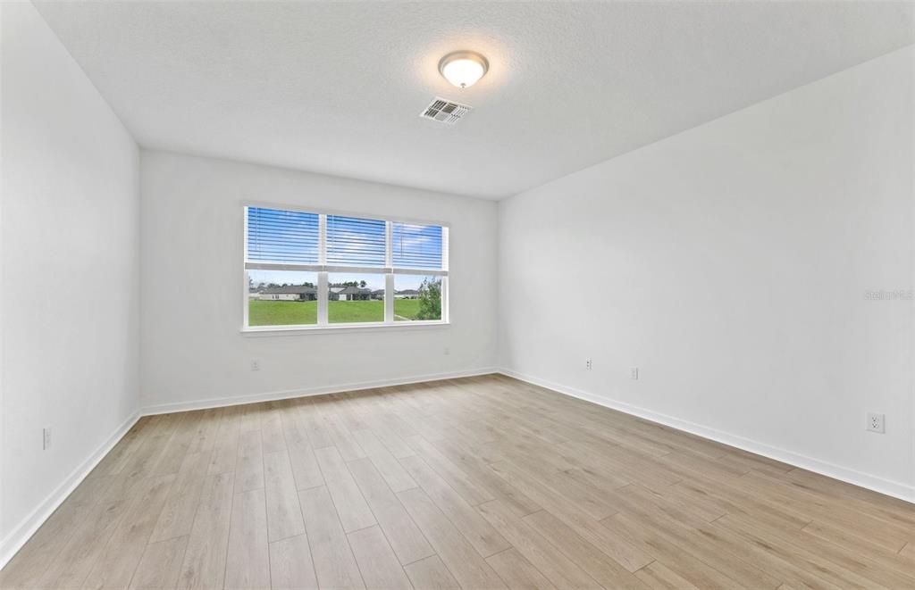 A modern kitchen features light-colored cabinetry, stainless steel appliances, and a white quartz island — 4278 OBSIDIAN DRIVE, SPRING HILL, FL