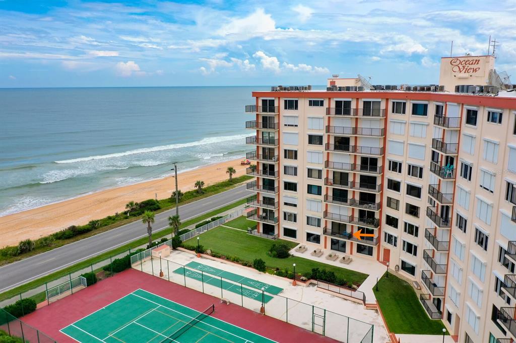 An aerial view of a beachfront condominium building with a tennis court and ocean views — 3600 S OCEAN SHORE BOULEVARD UNIT 214, FLAGLER BEACH, FL