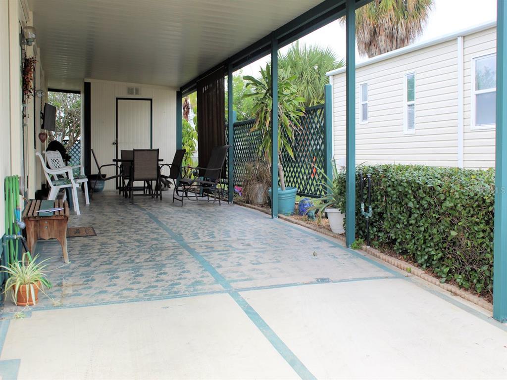 A covered patio with a concrete floor, outdoor furniture, and a privacy lattice screen — 802 DATE PALM STREET, LARGO, FL