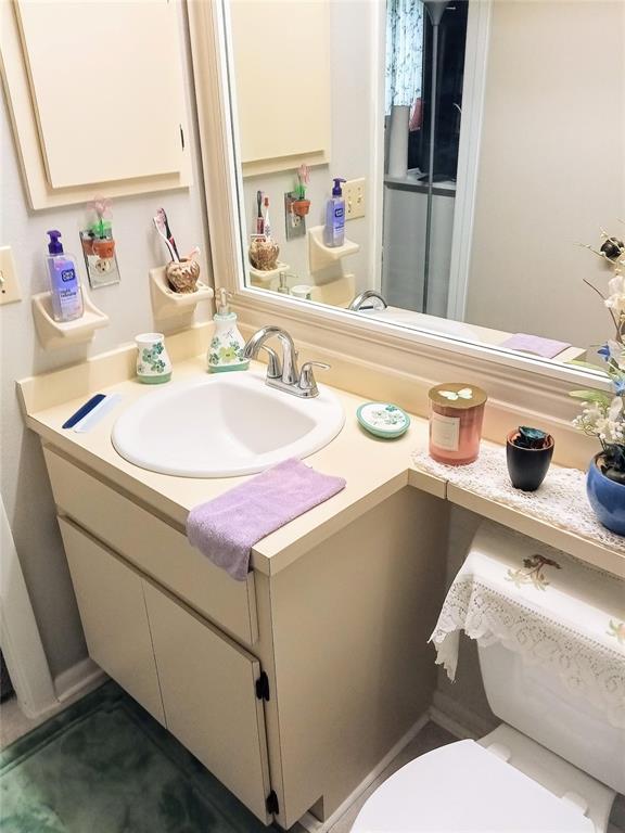 A bathroom vanity with a white sink, beige cabinets, and a large mirror — 6640 121ST AVENUE UNIT 1, LARGO, FL