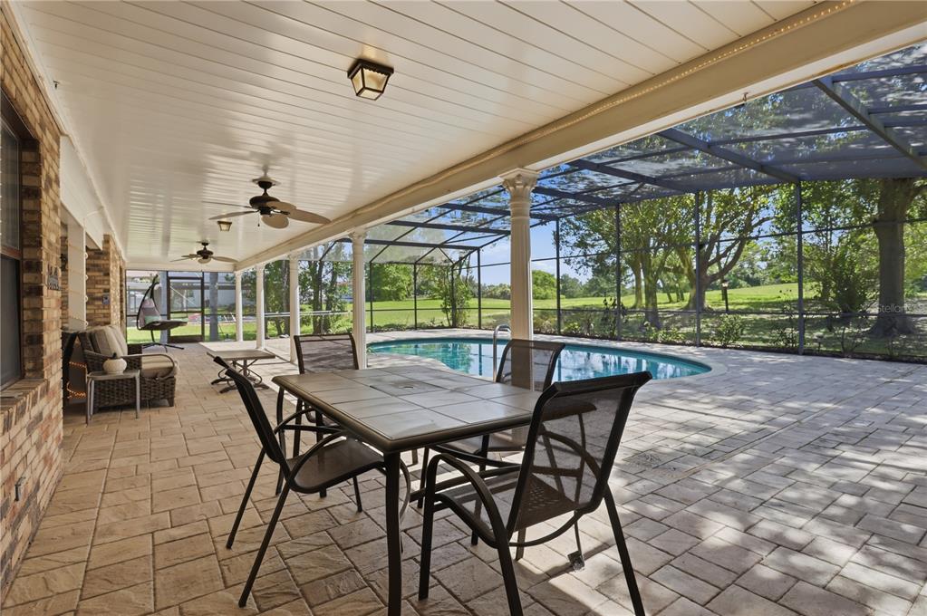 A covered patio with a dining set, lounge chairs, and a screened-in swimming pool — 2249 E UNION CIRCLE, DELTONA, FL