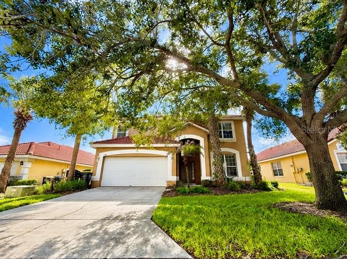 A two-story house with a tan stucco exterior and a red tile roof — 134 SEVILLA AVENUE, DAVENPORT, FL
