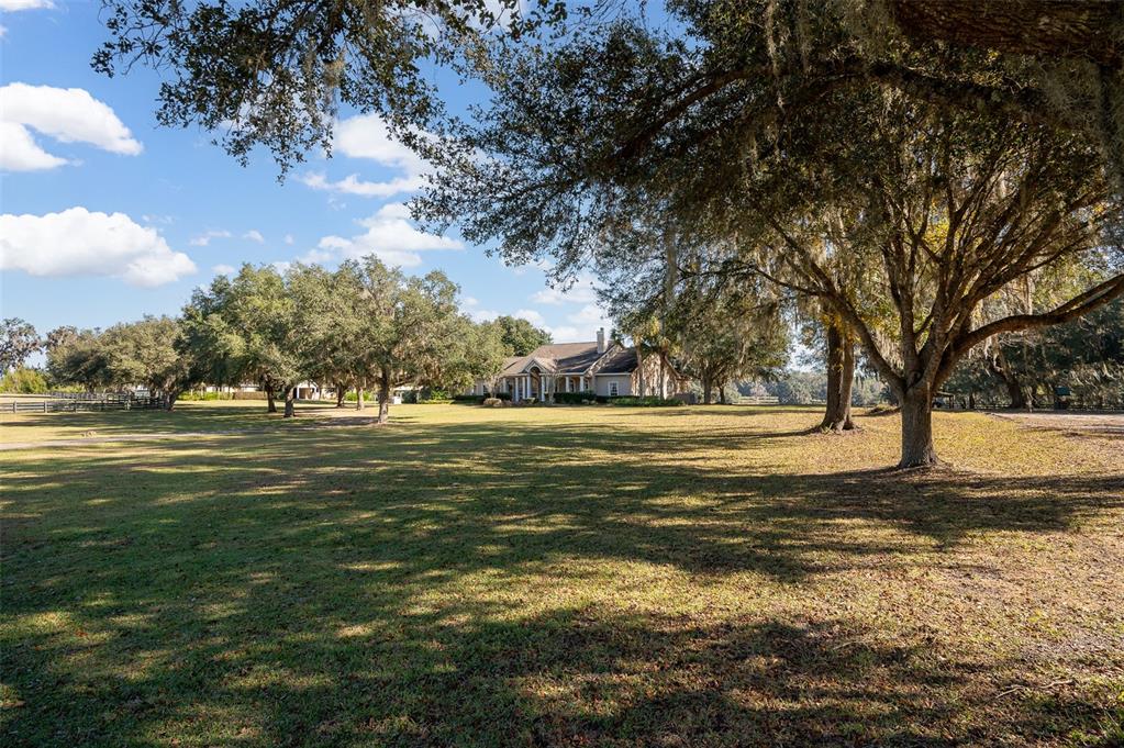 A brick driveway leads to a house with a two-car garage and a parked utility vehicle — 11715 NW 90TH AVENUE, REDDICK, FL