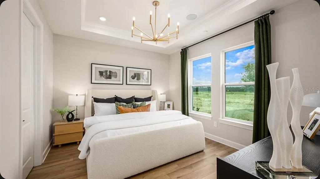 A living room features a sectional sofa, a green armchair, and a view of water — 4463 OCHOS RIOS PLACE, KISSIMMEE, FL