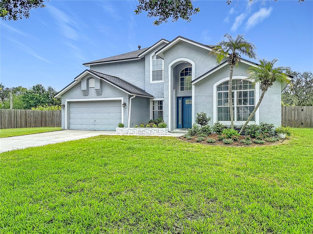 A two-story gray house with a two-car garage, arched entryway, and a front lawn — 1639 LEDGESTONE DRIVE, BRANDON, FL