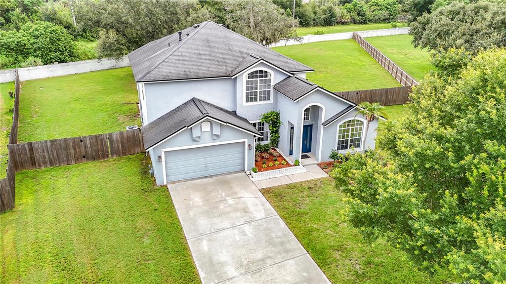 An aerial view of a two-story house with a gray exterior, shingled roof, and fenced yard — 1639 LEDGESTONE DRIVE, BRANDON, FL
