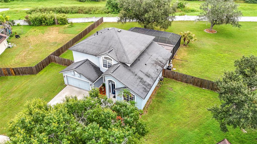 An aerial view of a two-story house with a shingled roof and a screened pool enclosure — 1639 LEDGESTONE DRIVE, BRANDON, FL