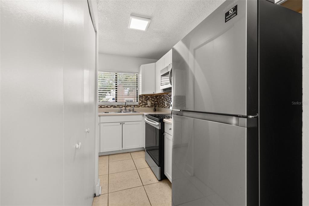 A living room with a brown sectional sofa, a glass coffee table, and adjacent dining area — 111 MICHELLE LANE UNIT B, KISSIMMEE, FL