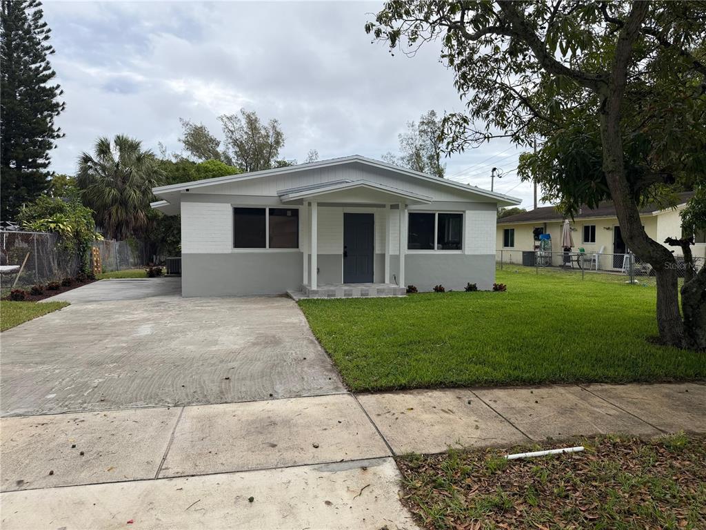 A single-story house with a gray and white exterior, a concrete driveway, and a lawn — 836 SW 2ND TERRACE, DEERFIELD BEACH, FL