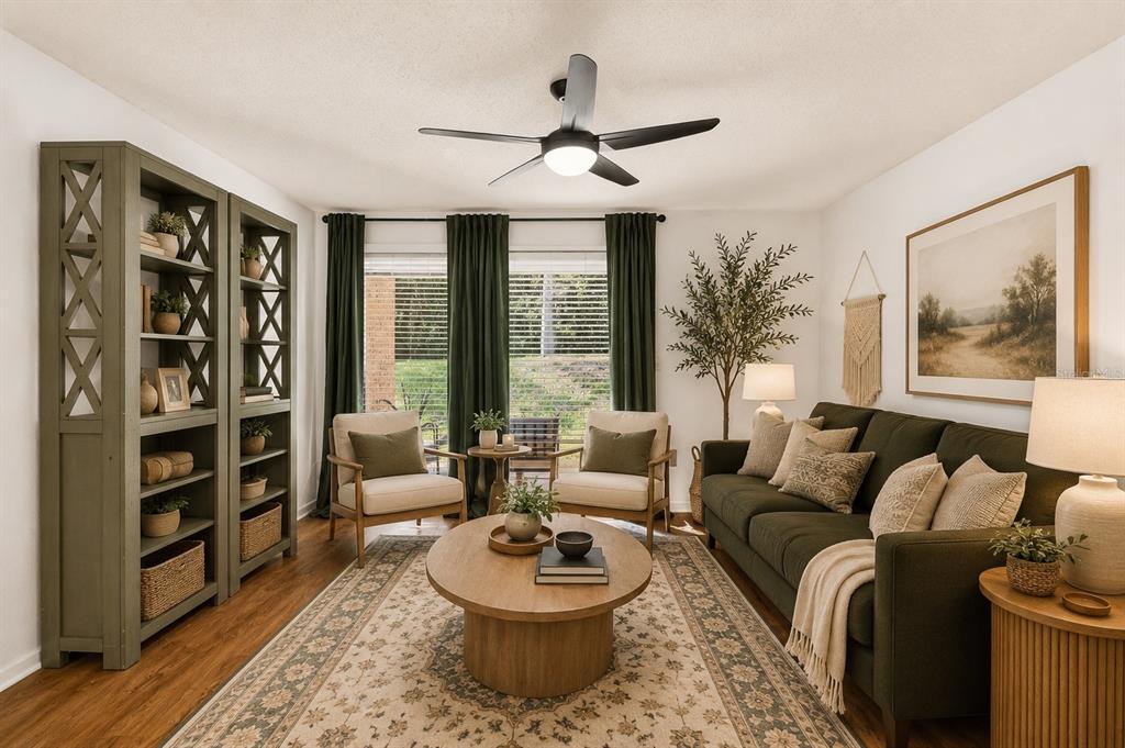 A living room features a green sofa, two armchairs, a round coffee table, and bookshelves — 1810 NW 23RD BOULEVARD UNIT 230A, GAINESVILLE, FL