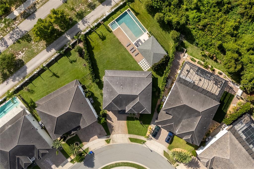 A two-story house with a gray stucco exterior, stone accents, and a three-car garage — 8192 LUDINGTON CIRCLE, ORLANDO, FL