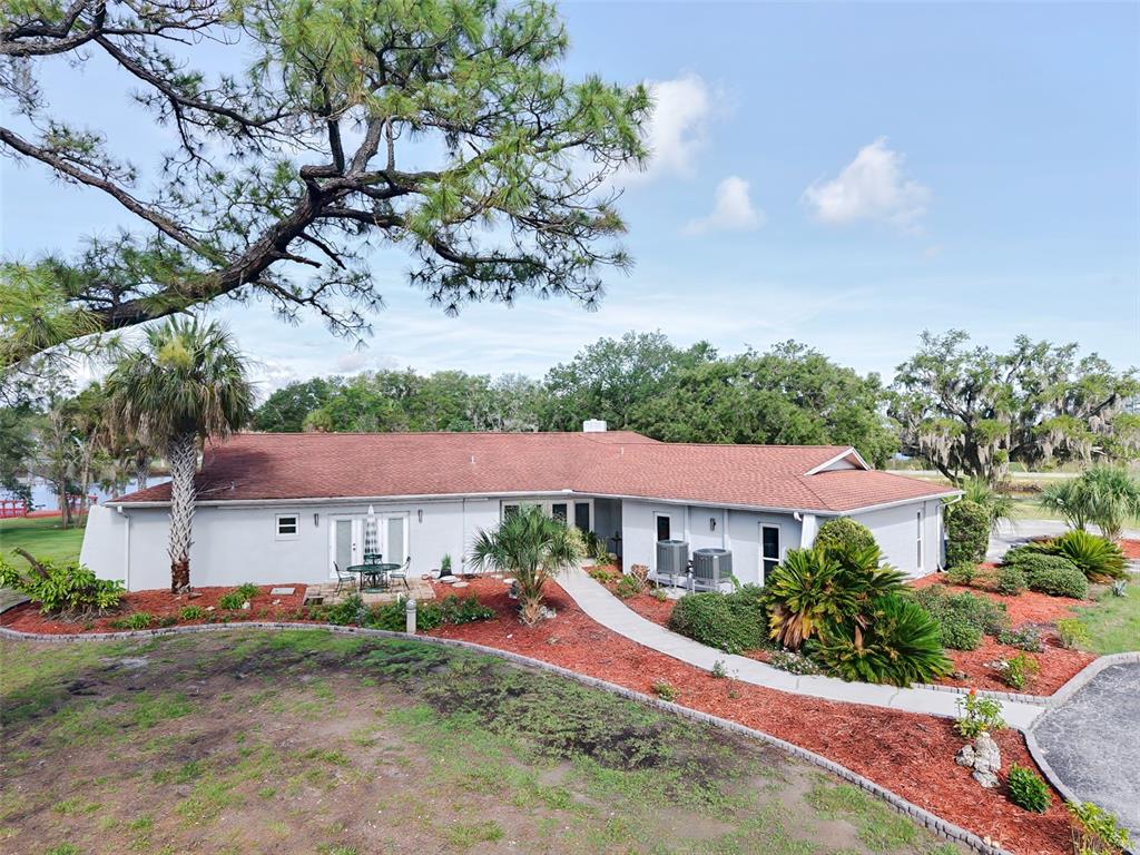 An exterior view of a single-story house with a red roof and landscaped yard — 11580 W DIXIE SHORES DRIVE, CRYSTAL RIVER, FL