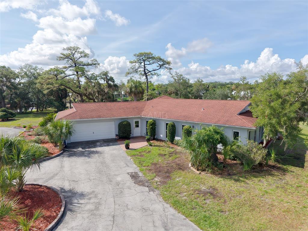 An aerial view of a single-story house with a red roof and a paved driveway — 11580 W DIXIE SHORES DRIVE, CRYSTAL RIVER, FL