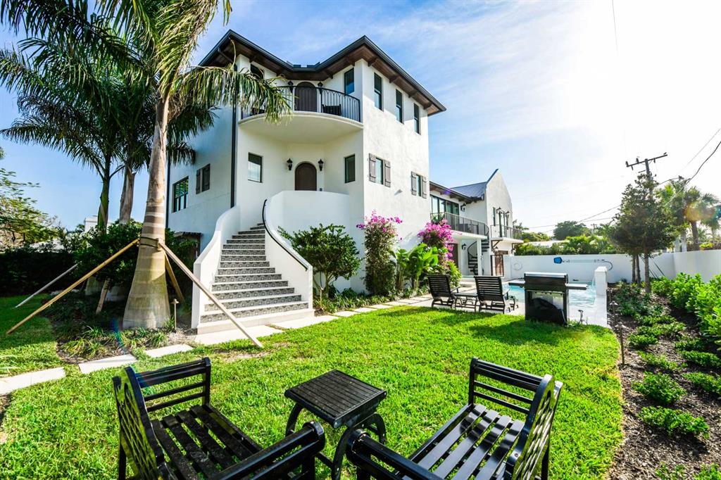 A white multi-story house features an exterior staircase, a balcony, and a backyard swimming pool — 340 JACKSON DRIVE, SARASOTA, FL