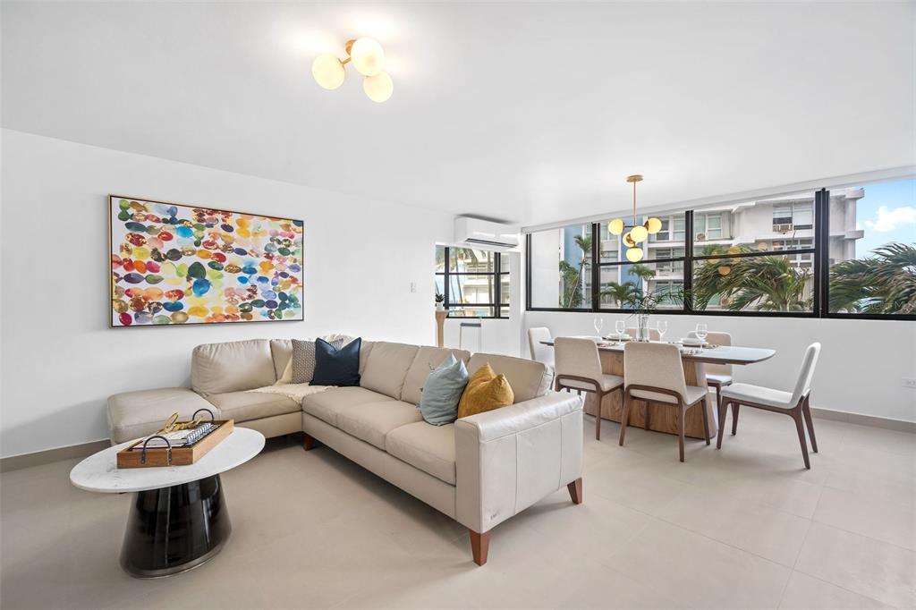 A bright living and dining area features a beige sectional sofa, marble table, and windows — 2 Condado Princess WASHINGTON STREET UNIT 103, SAN JUAN, PR