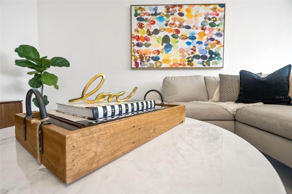 A wooden tray with books and a gold love sign sits on a marble table — 2 Condado Princess WASHINGTON STREET UNIT 103, SAN JUAN, PR