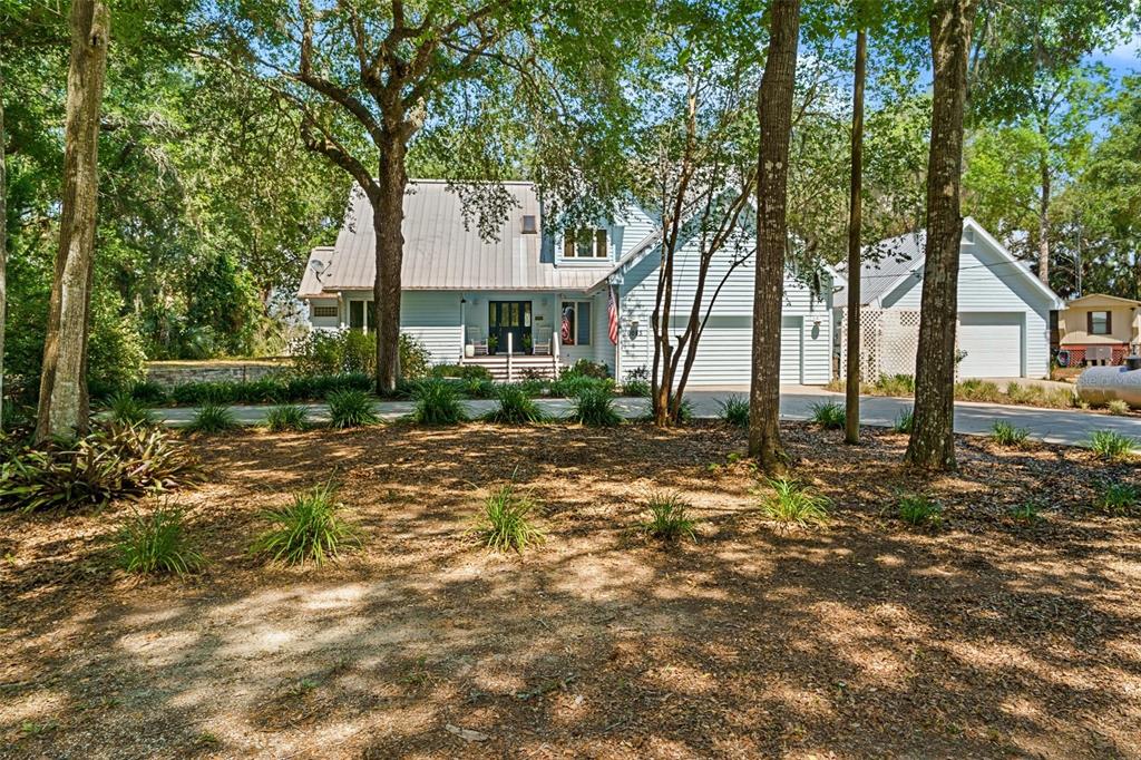 A light blue two-story house with a metal roof and a multi-car garage — 6085 S ROYAL DRIVE, HOMOSASSA, FL