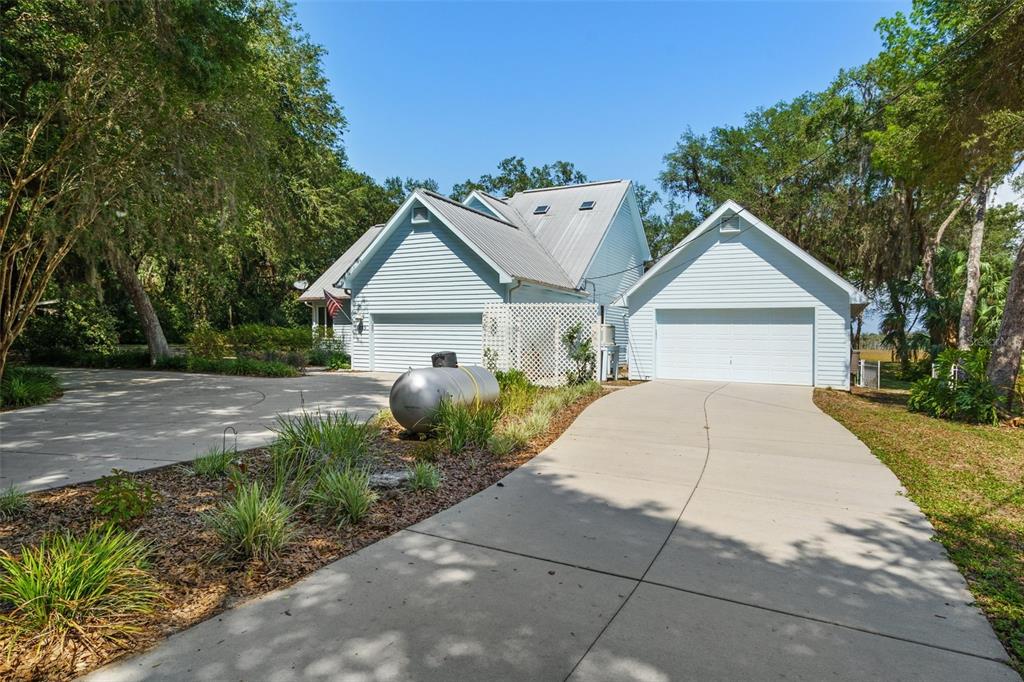 A light blue house with a metal roof and two separate garage entrances — 6085 S ROYAL DRIVE, HOMOSASSA, FL