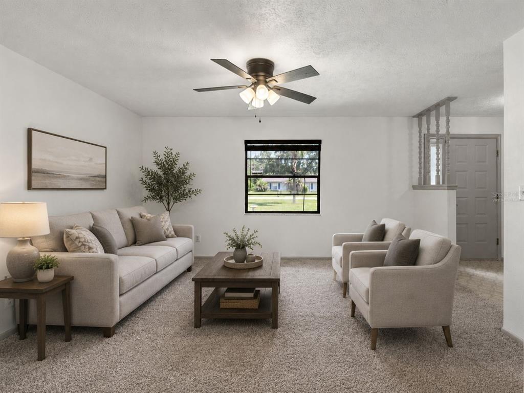A living room with a sofa, two armchairs, a coffee table, and a ceiling fan — 37216 ORANGE BLOSSOM LANE, DADE CITY, FL