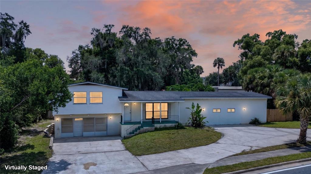 A two-story house with white siding, a concrete driveway, and a large front lawn — 1220 HOWELL BRANCH ROAD, WINTER PARK, FL
