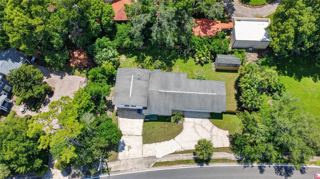 An aerial view shows a house with a gray roof, a driveway, and surrounding trees — 1220 HOWELL BRANCH ROAD, WINTER PARK, FL