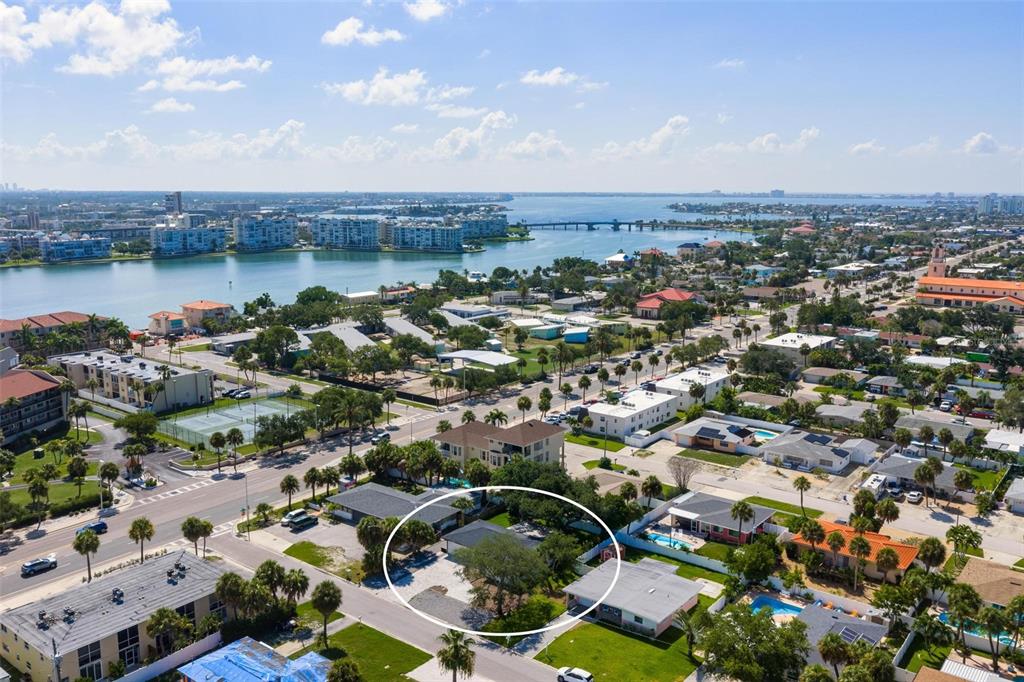 An aerial view shows a single-story house with a dark roof circled in a neighborhood — 406 88TH AVENUE, ST PETE BEACH, FL