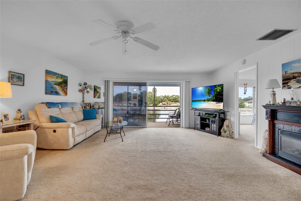 An exterior view of a two-story apartment building with screened balconies overlooking a canal — 4470 NARRAGANSET TRAIL UNIT 90A, SARASOTA, FL