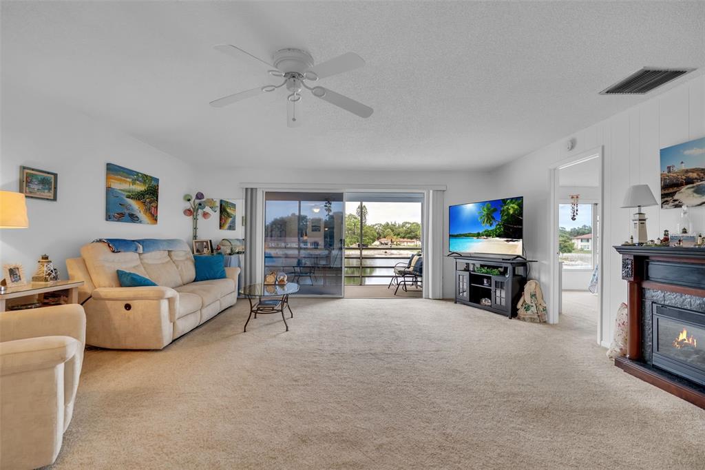 A bedroom features a bed with a tropical print comforter, light-colored furniture, and a window view — 4470 NARRAGANSET TRAIL UNIT 90A, SARASOTA, FL