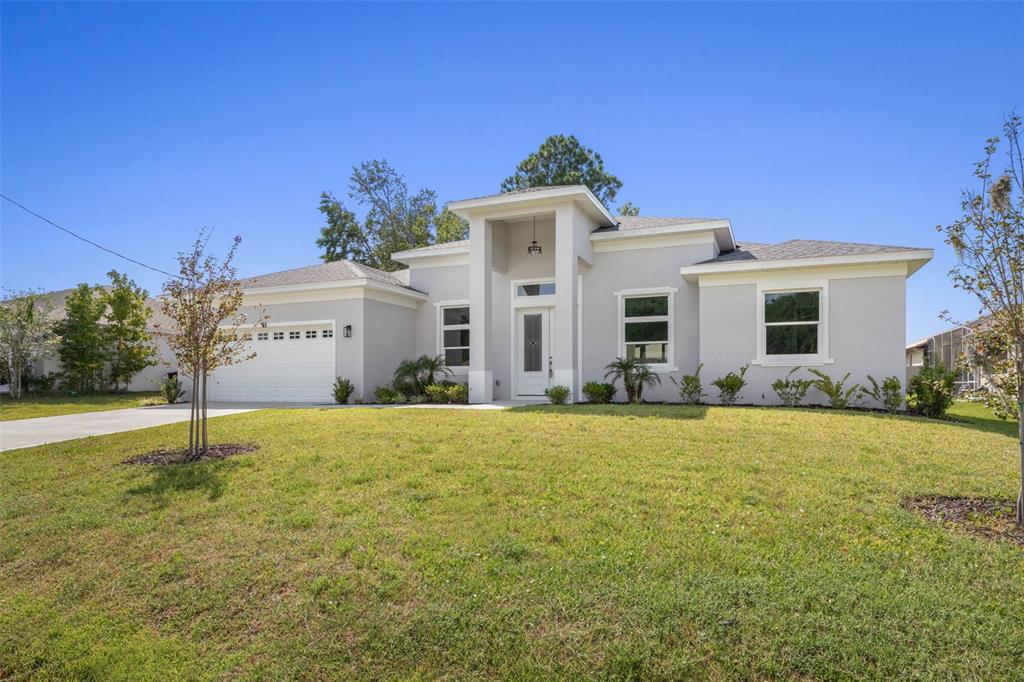 A single-story light gray house with a white garage and a central covered entryway — 45 FARMSWORTH DRIVE, PALM COAST, FL