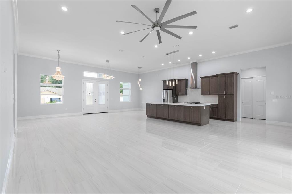 A spacious open-concept kitchen and living area featuring dark cabinetry, a large island, and tile flooring — 45 FARMSWORTH DRIVE, PALM COAST, FL
