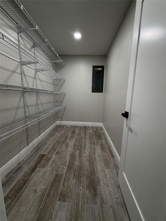 A walk-in pantry with wire shelving, wood-look tile flooring, and an electrical panel on the wall — 8715 DRIFTWOOD DRIVE, TAMPA, FL