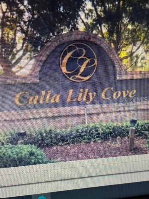 A stone monument sign displays the name Calla Lily Cove with a circular logo — 5418 CALLA LILY COURT, KISSIMMEE, FL