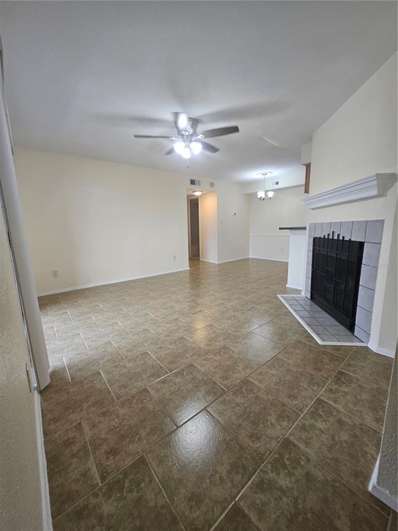 A living room features a tiled fireplace, beige walls, and a white front door — 9100 DR MARTIN LUTHER KING JR STREET N UNIT 202, ST PETERSBURG, FL