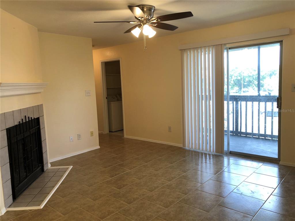 A living room with tile flooring, a ceiling fan, and a fireplace with a mantel — 9100 DR MARTIN LUTHER KING JR STREET N UNIT 202, ST PETERSBURG, FL