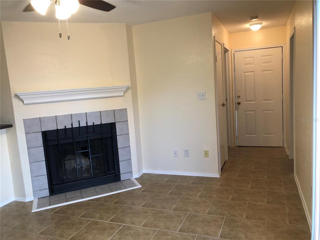A living room features tile flooring, a fireplace, a ceiling fan, and a sliding glass door — 9100 DR MARTIN LUTHER KING JR STREET N UNIT 202, ST PETERSBURG, FL