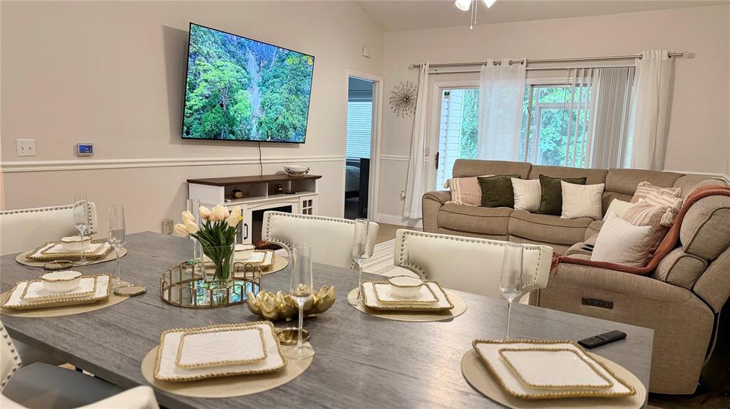 A dining area with a gray table and white chairs opens into a living room — 4700 SW ARCHER ROAD UNIT 26, GAINESVILLE, FL