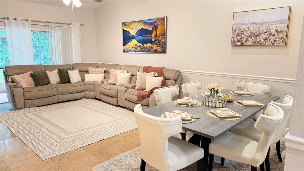 An open-concept living and dining area features a large sectional sofa and a dining table — 4700 SW ARCHER ROAD UNIT 26, GAINESVILLE, FL