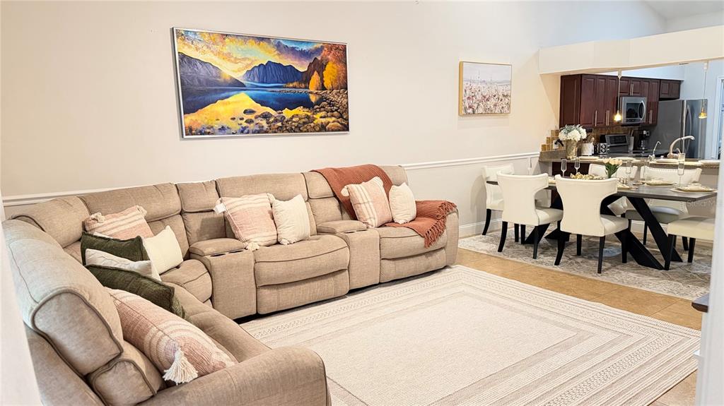 A living room with a large sectional sofa, area rug, and adjacent dining area — 4700 SW ARCHER ROAD UNIT 26, GAINESVILLE, FL