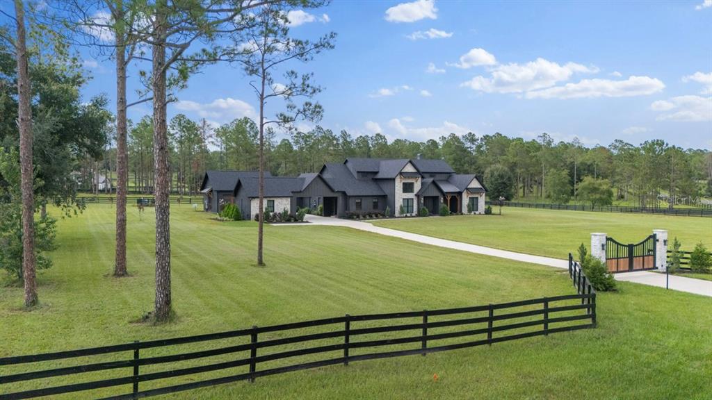 An aerial view shows a dark-roofed house with a long driveway on a large, fenced lot — 23741 RIDGE LINK ROAD, EUSTIS, FL